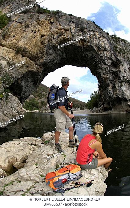 Hikers in front of a natural stone arch, Vallon Pont d'Arc, Ardeche, Rhone Alps, France, Europe