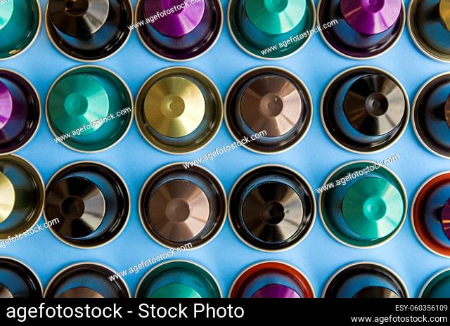 Beautiful colored coffee capsules on light blue background