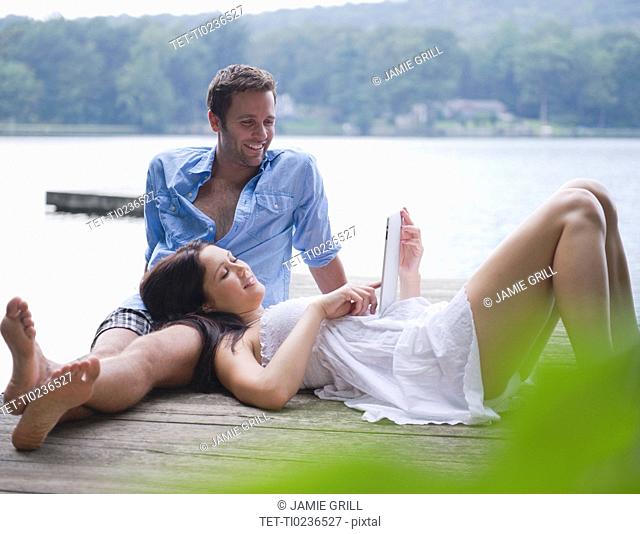 USA, New York, Putnam Valley, Roaring Brook Lake, Couple relaxing on pier by lake