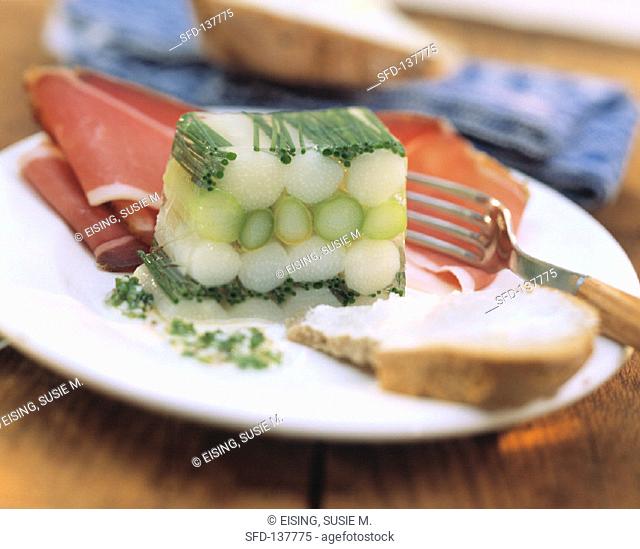White & green asparagus jelly with ham on a plate