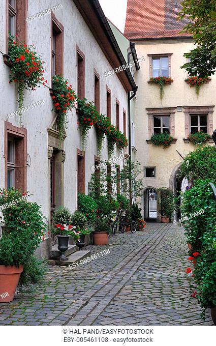 bishofhof courtyard with flowers, regensburg. foreshortening of courtyard in the ancient building in city center