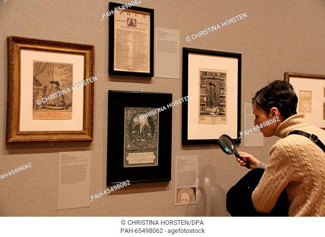 A woman is looking with a magnifying glass at in the Buchinger exhibition at the Metropolitan Museum in New York, US, pictures that Matthias Buchinger be seen
