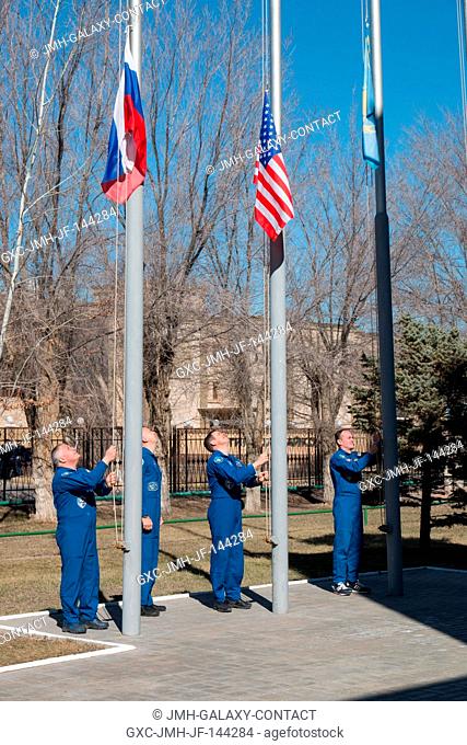 At the Cosmonaut Hotel crew quarters in Baikonur, Kazakhstan, the Expedition 51 prime and backup crewmembers raise the flags of Russia, the U.S