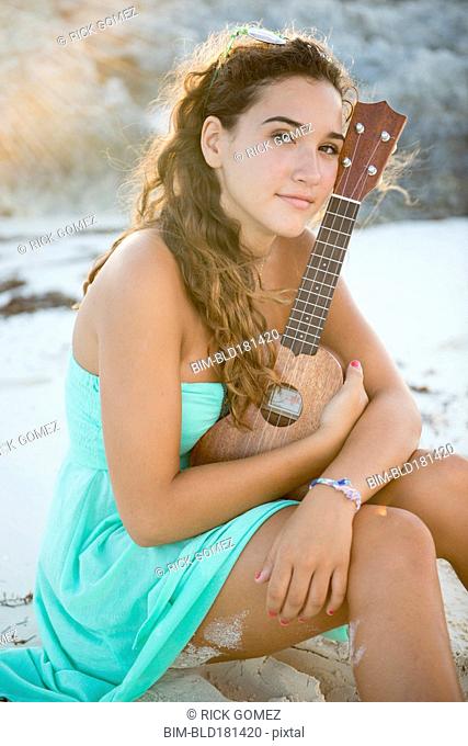 Hispanic teenage girl holding ukulele