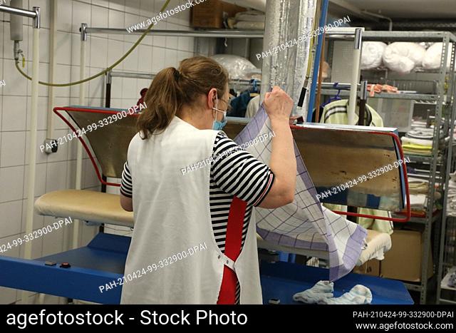 23 April 2021, Thuringia, Gera: A woman works in the laundry of Lebenshilfe Gera e.V.. Workshops for people with disabilities hope for better support