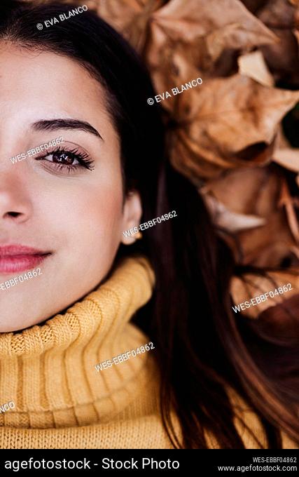 Smiling woman on dry leaves
