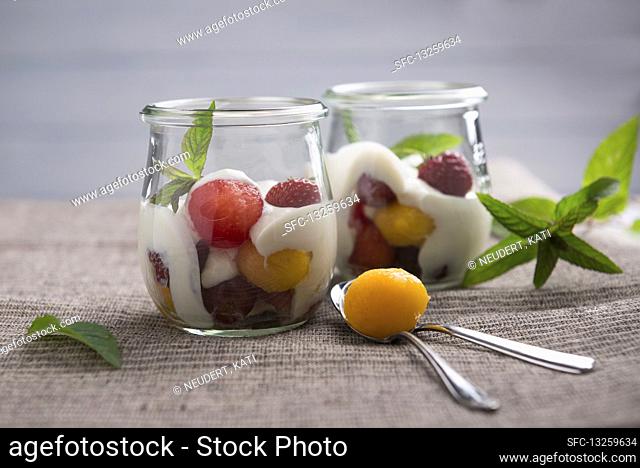 Soya yoghurt with melon and peach ball, strawberries and red grapes