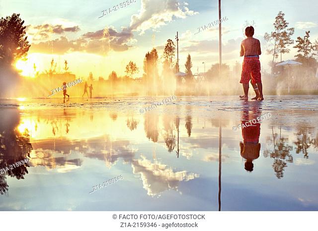 Children having fun with water fountains at Madrid Rio park. Madrid. Spain