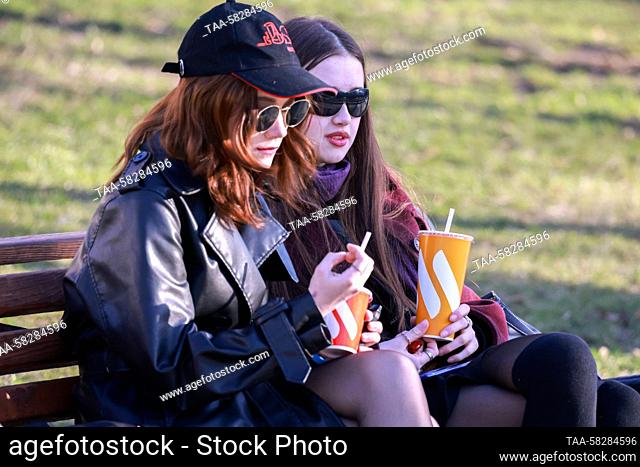 RUSSIA, MOSCOW - APRIL 7, 2023: Two girls sit on a bench in Tverskoy Boulevard. Vladimir Gerdo/TASS