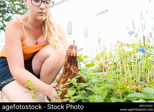 A girl and her chicken in the garden
