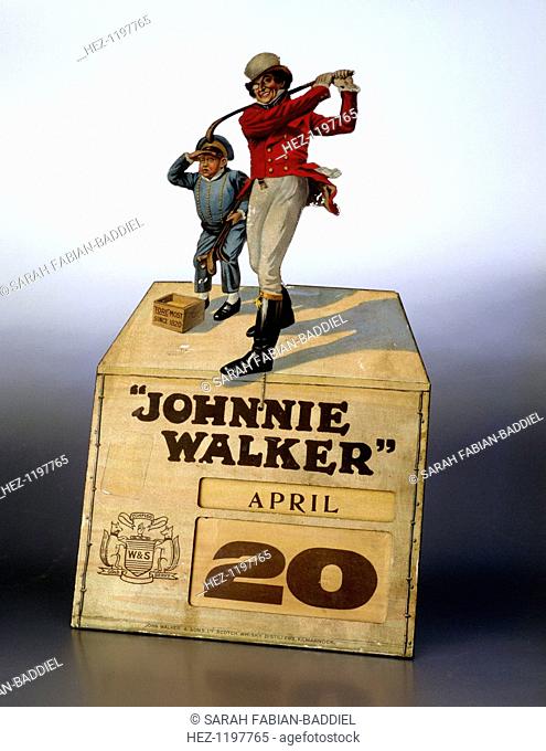 Johnnie Walker calendar. Coloured tinplate figures of Johnny Walker and a caddy on a cardboard box containing a perpetual calendar