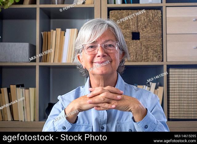 Portrait of one old cheerful female senior smiling having fun at home. Attractive mature caucasian woman studying independent looking at the camera and posing...