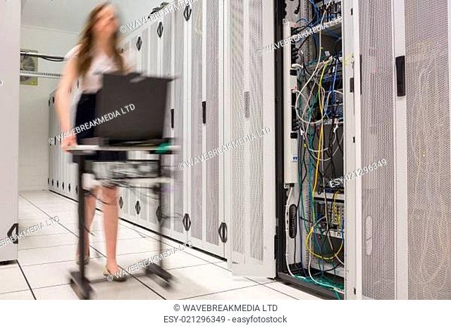 Woman pushing computer to open servers in data center