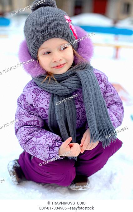 Close-up of Little cute happy girl having fun in the snow on a sunny winter day