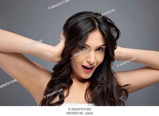 Beautiful young woman with her hands covering her ears over colored background