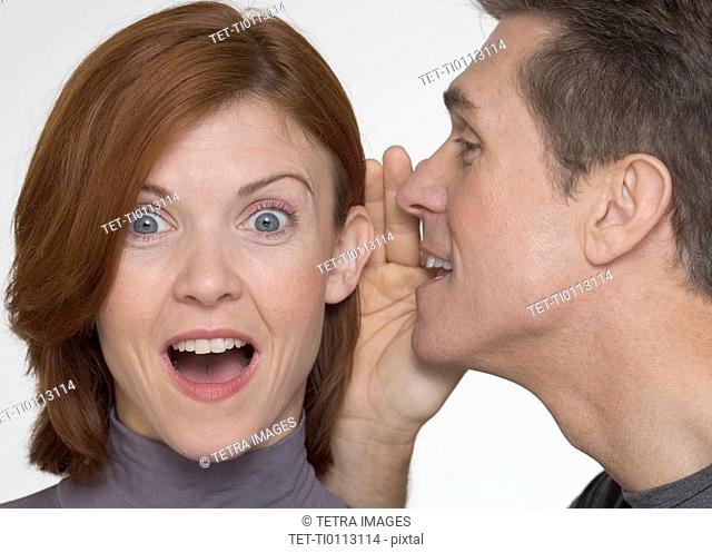 Man telling woman surprising secret