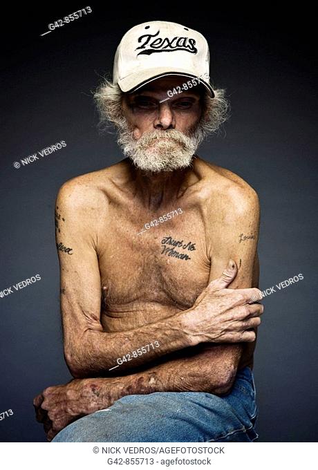 Portrait of man displaying a tattoo that says 'Trust No Woman'
