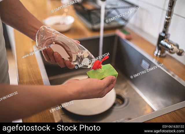 Dish washing. Man washing dishes in the kitchen