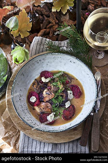 Mushroom broth with beetroot dumplings, cheese, dill, mushrooms and red cabbage