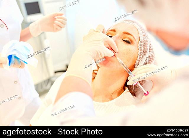 Frau beim Lippen aufspritzen mit Hyaluronsäure beim Facharzt für ästhetische Chirurgie