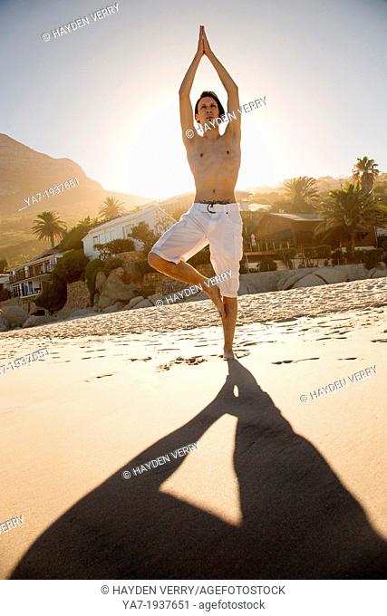 Man Doing Yoga On The Beach