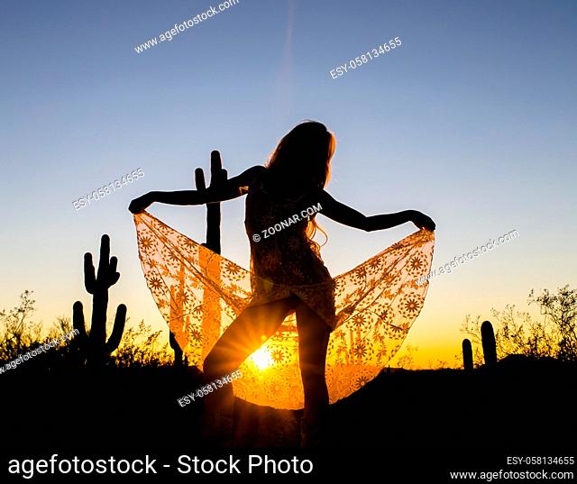 A model posing in the desert of the American Southwest at sunset