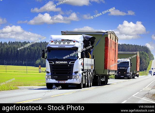 Two silver Scania trucks Nosto ja Kuljetus S. Lehtinen Oy haul portable cabin as exceptional load in convoy. Jokioinen, Finland. June 15, 2020