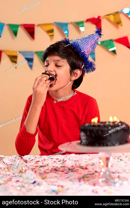 Portrait of boy eating his birthday cake