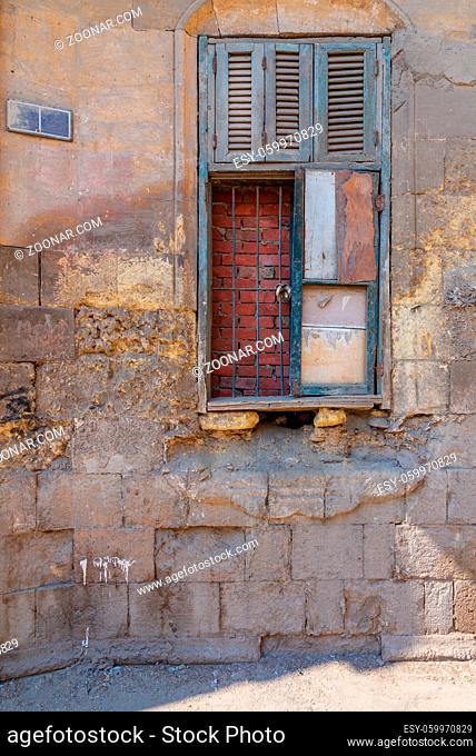 Broken windows and grunge stone bricks wall in abandoned Darb El Labana district, Cairo, Egypt