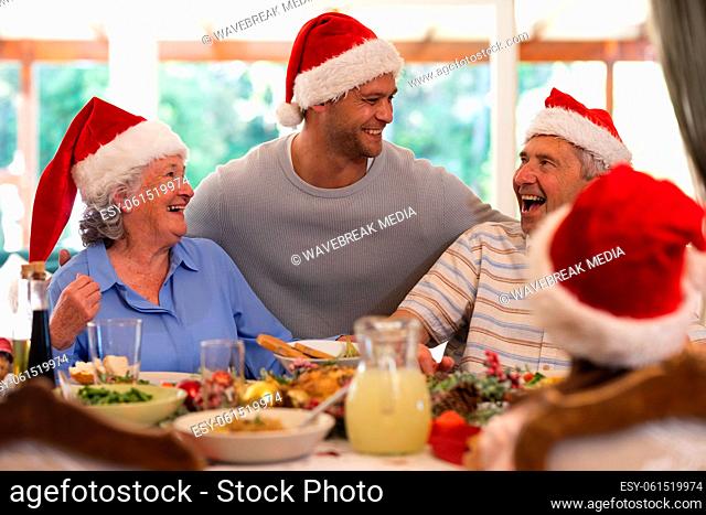 Senior caucasian couple and their adult son sitting at table for dinner together