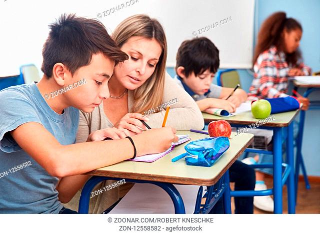 Lehrerin bei der Hausaufgaben Betreuung mit Schüler in der Grundschule