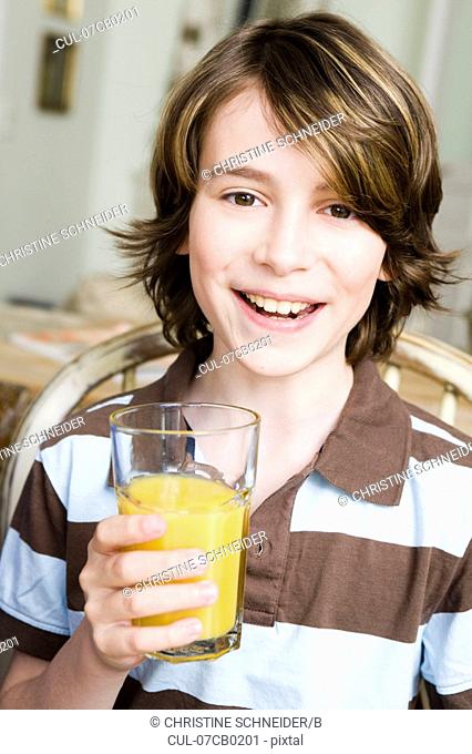 Boy smiling with a glass of orange juice