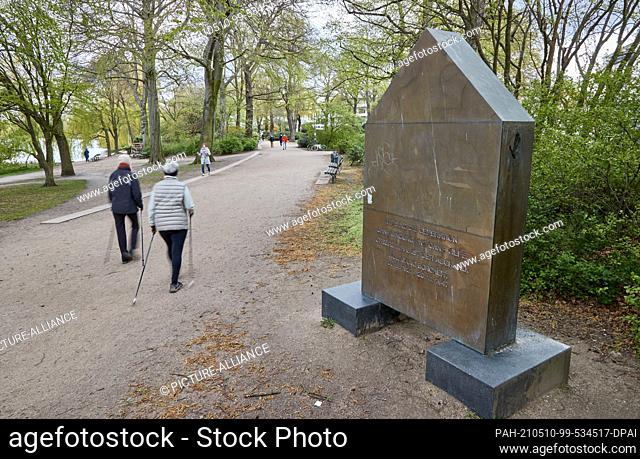 07 May 2021, Hamburg: Two Nordic walkers pass the monument to the writer Wolfgang Borchert at Schwanenwik on the Outer Alster