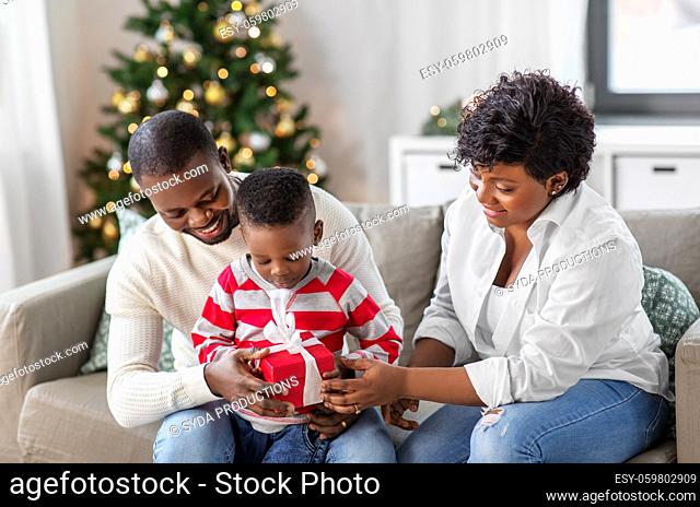 african family opening christmas gift at home
