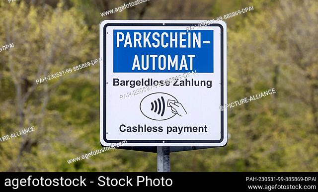 07 May 2023, Schleswig-Holstein, Travemünde: A sign with the inscription ""Parking ticket machine, cashless payment"" indicates the possibility of cashless...
