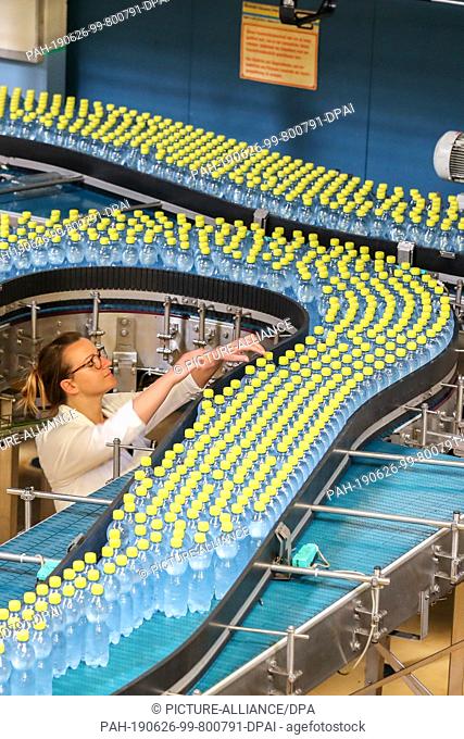 24 June 2019, Saxony, Eilenburg: An employee monitors the filling of Ileburger mineral water with lemon taste at Sachsenquelle GmbH