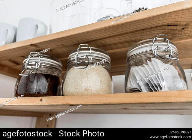 Tea, coffee and sugar in preserving jars on wooden shelf. South Africa