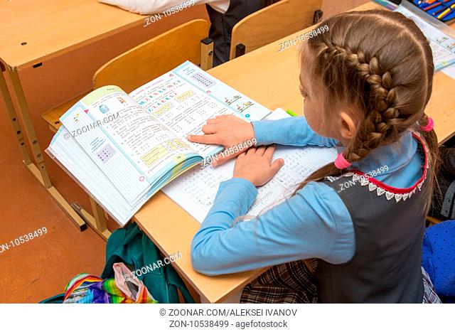 Anapa, Russia - February 28, 2017: Schoolgirl reading condition problems in the textbook