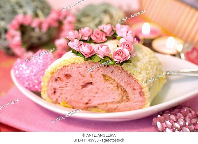 Raspberry and strawberry Swiss roll decorated with rose decorations for Valentine's Day