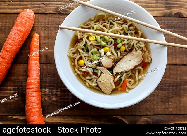 Shoyu chicken Tokyo style ramen soup with carrots on wooden rustic table top