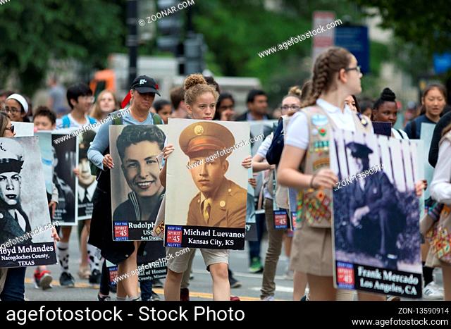 Washington, D.C., USA - May 28, 2018: The National Memorial Day Parade, People carry portraits of world war two military personel down constitution avenue