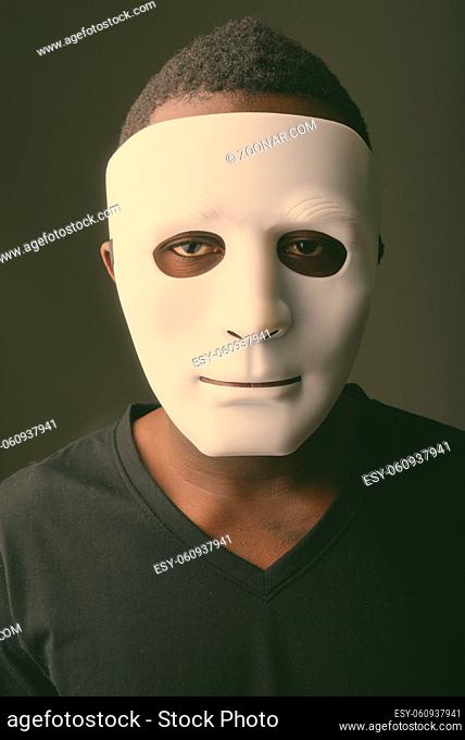 Studio shot of young African man with white mask against white background