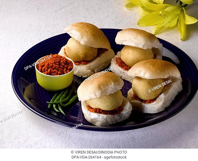Indian snack wada pav with chilies and red chili powder, India, Asia