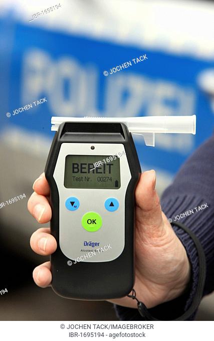 Police officer with breathalyser for checking the fitness to drive