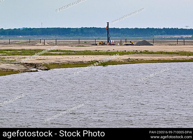 16 May 2023, Brandenburg, Cottbus: View across the water of the future Baltic Sea to the construction site for a floating photovoltaic plant