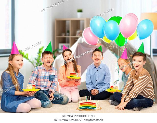 happy children in party hats with birthday cake