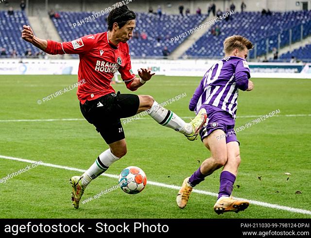 30 October 2021, Lower Saxony, Hanover: Football: 2nd Bundesliga, Hannover 96 - Erzgebirge Aue, Matchday 12, HDI Arena. Hannover's Sei Muroya (l) and Aue's Sam...