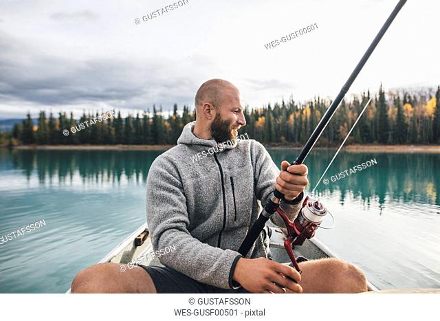 Canada, British Columbia, man fishing in canoe on Boya Lake