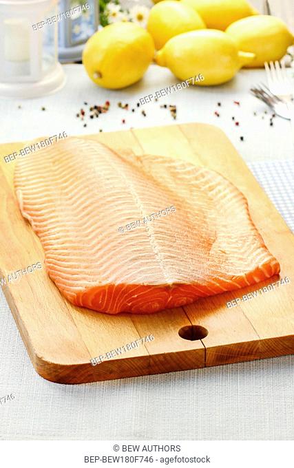 Big raw salmon fillet on wooden table
