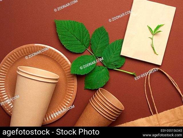 disposable paper utensils from brown craft paper and recycled materials on a brown background, plastic rejection concept, zero waste